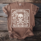 Brown t-shirt with a distressed graphic of a skull, bones, and plants with text.