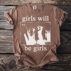 Brown t-shirt with glowing-eyed witches graphic and text "girls will be girls".