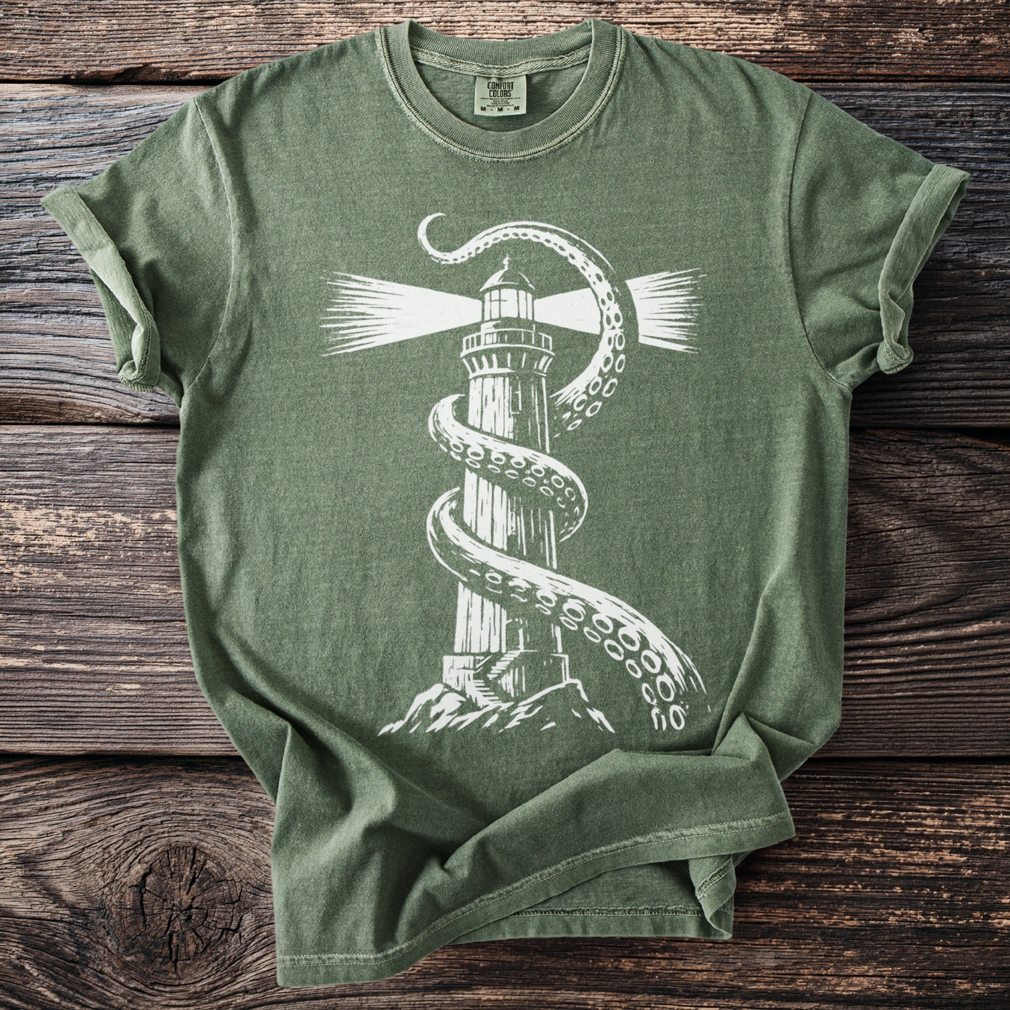 Green t-shirt with white graphic of kraken tentacles wrapped around a lighthouse.