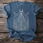 Blue t-shirt with mystical woman, moon, birds, skulls, and thorny vines graphic.