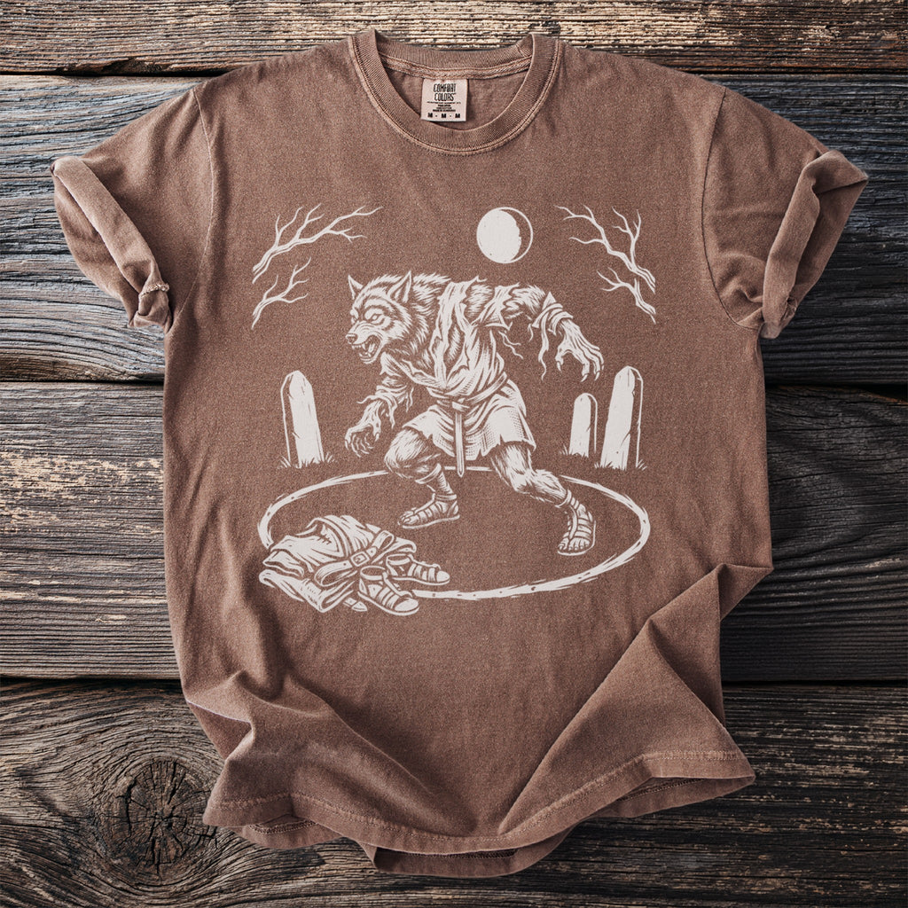 Brown t-shirt with white line art of a werewolf in a graveyard under a full moon.