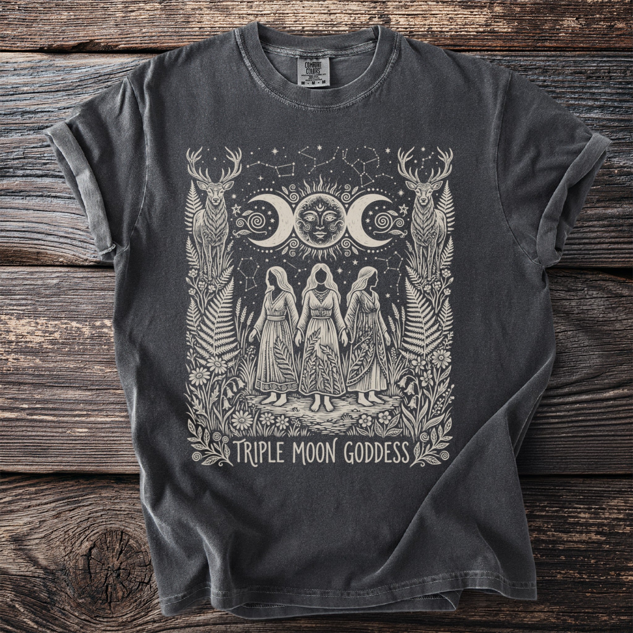 Dark grey t-shirt with cream graphic of three women, crescent moons, sun, deer, and text.