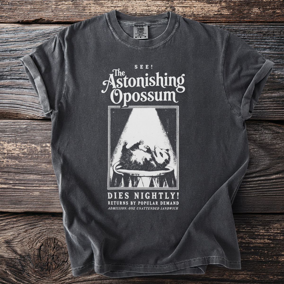 Dark gray t-shirt with "The Astonishing Opossum Dies Nightly!" text and graphic.