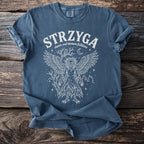 Blue t-shirt with white graphic of a winged, mythological Slavic creature titled STRZYGA.