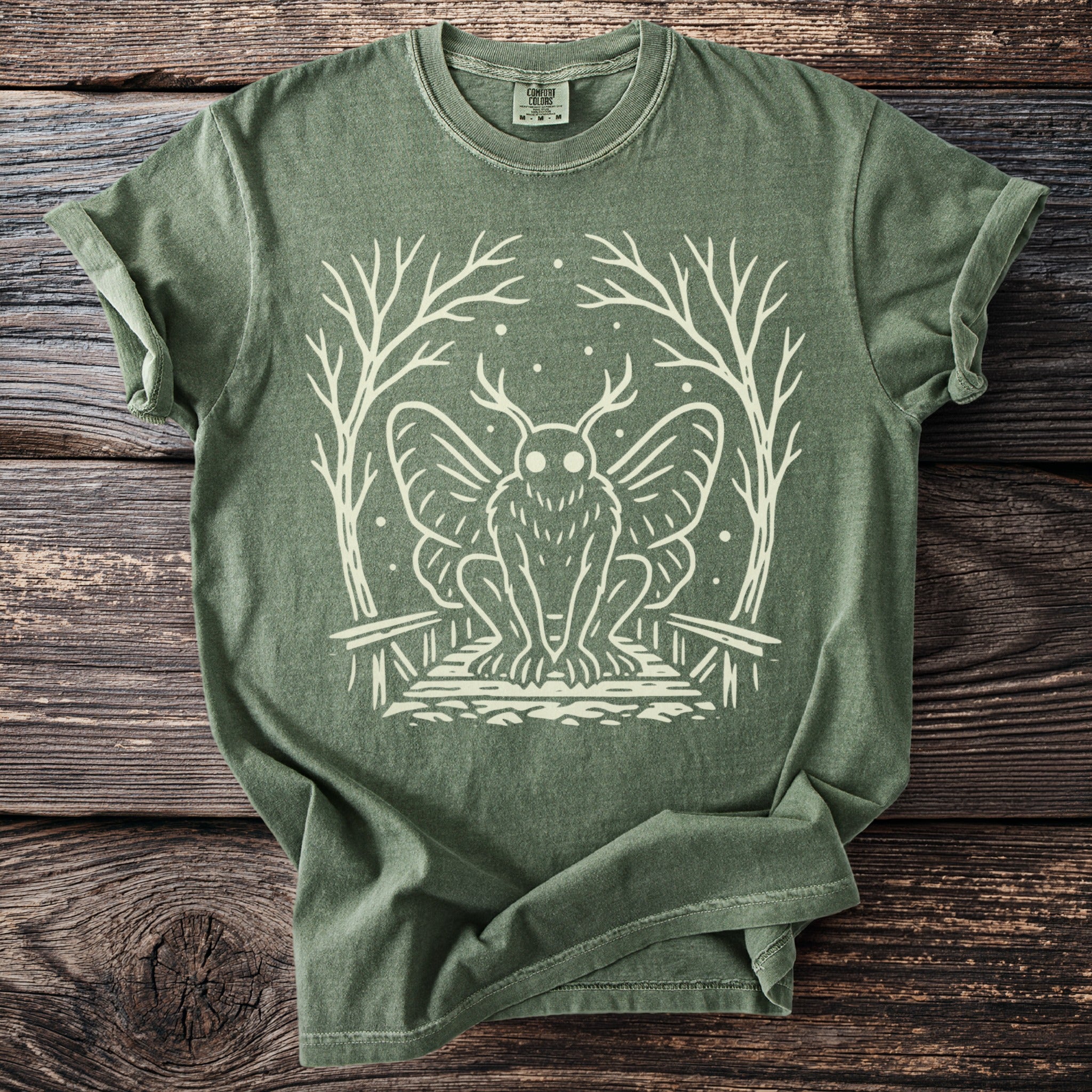 Green t-shirt with white mothman illustration and Comfort Colors tag.