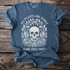 Blue t-shirt with skull and floral design, text reads "ALL PLANTS ARE EDIBLE SOME ONLY ONCE".
