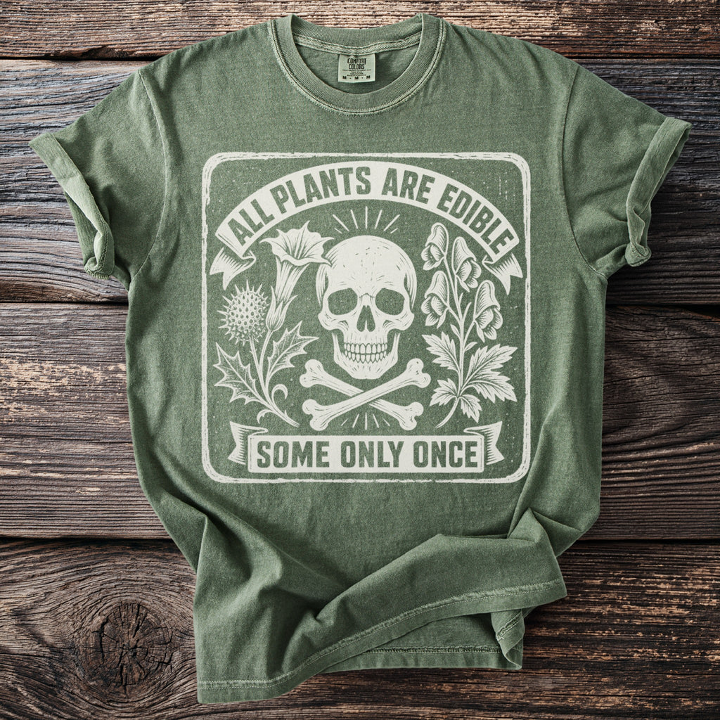 Green t-shirt with skull, crossbones, plants, and text that reads "ALL PLANTS ARE EDIBLE SOME ONLY ONCE."