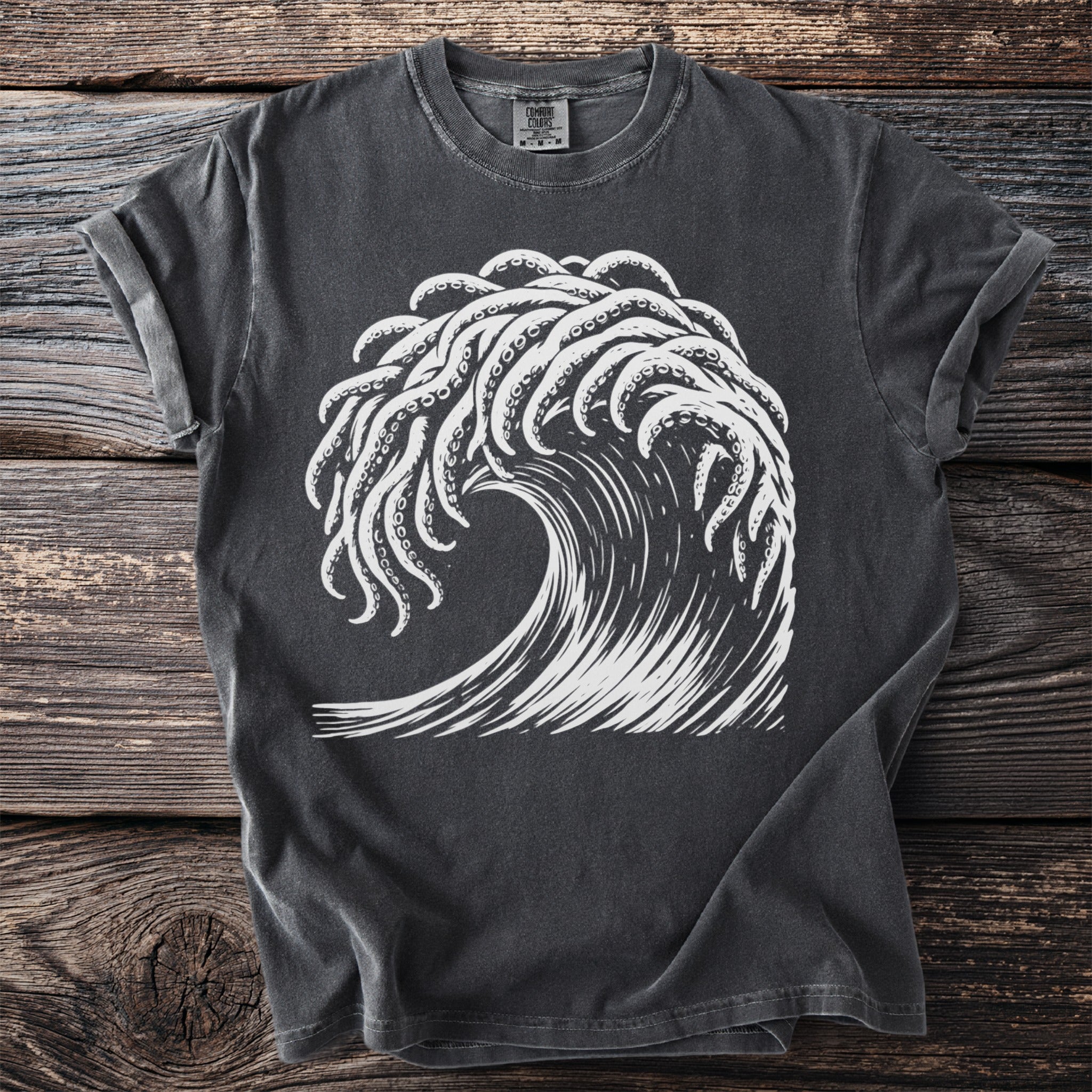 Dark gray t-shirt with white graphic of crashing wave and octopus tentacles.