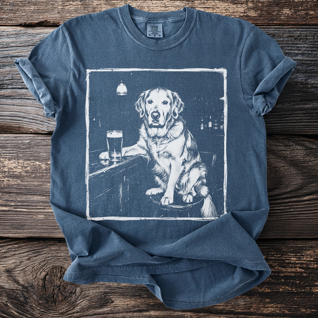 Blue t-shirt with a white graphic of a golden retriever at a bar with a beer.