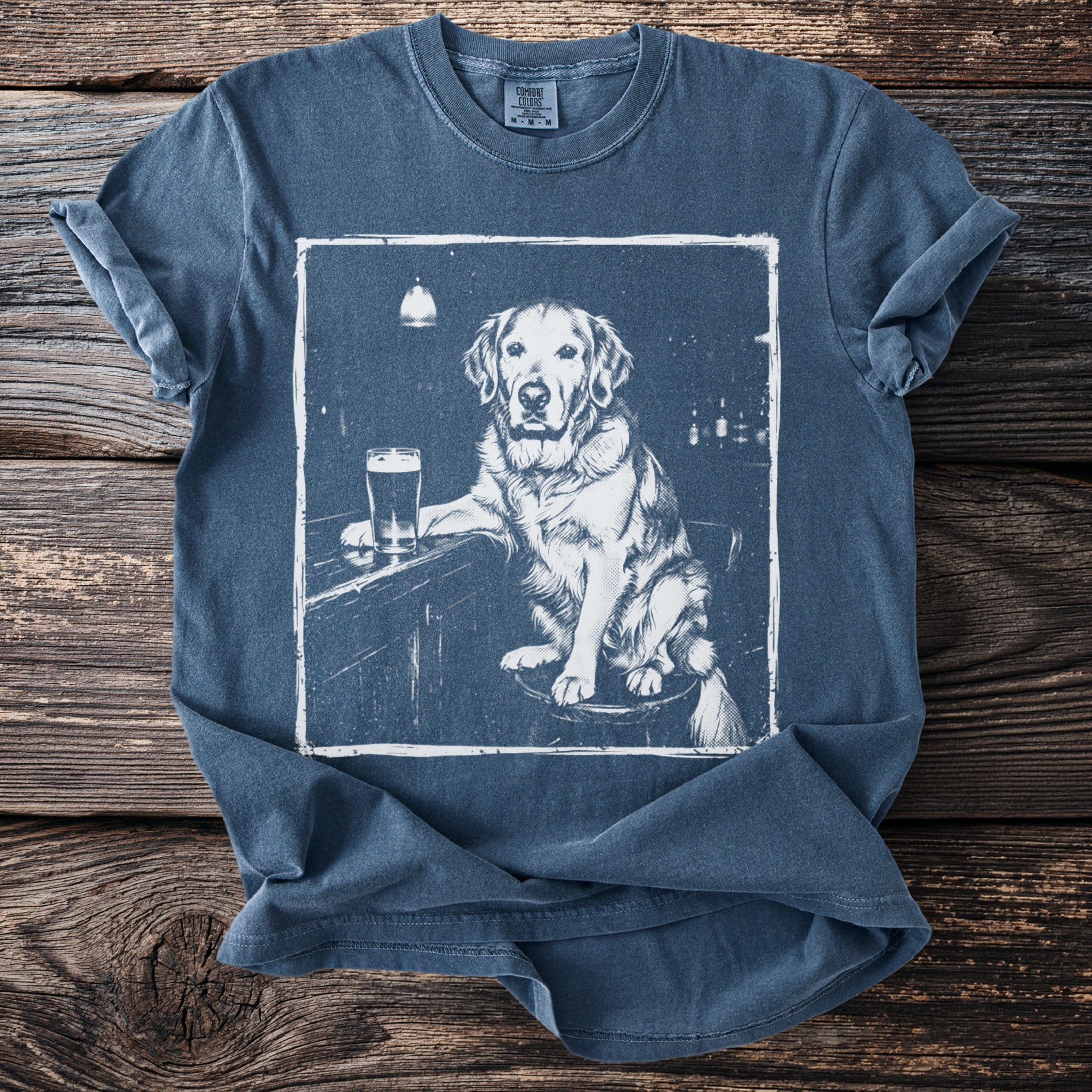 Blue t-shirt with a white graphic of a golden retriever at a bar with a beer.