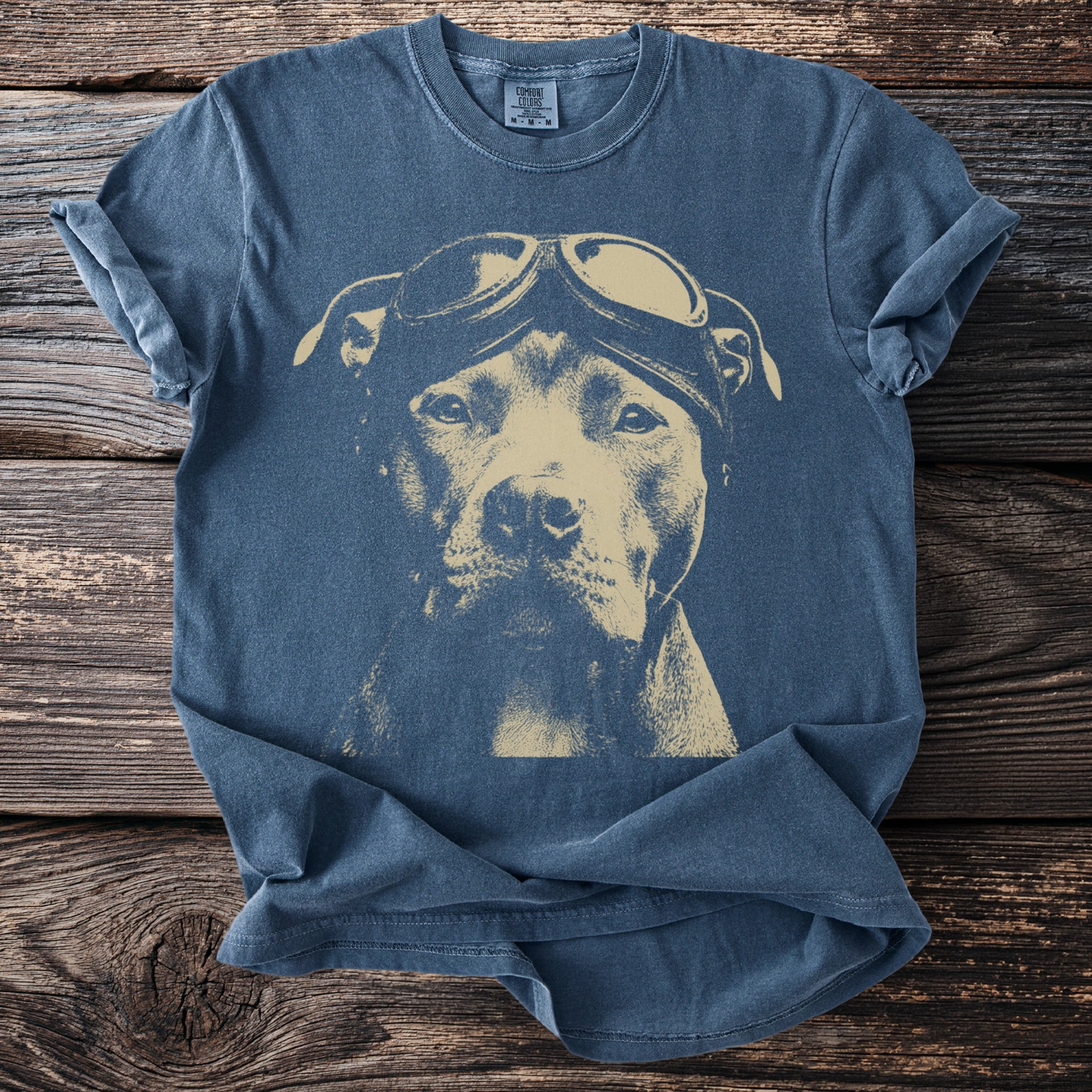 Blue t-shirt with tan graphic of a pit bull wearing aviator goggles.
