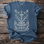 Blue t-shirt with a white Thor's hammer, runes, crows, trees, and candles graphic.