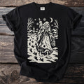 Black t-shirt with a cream folk-cut print: Perchta walks through a snowy village with a lantern and a spindle, goose footprints behind her.
