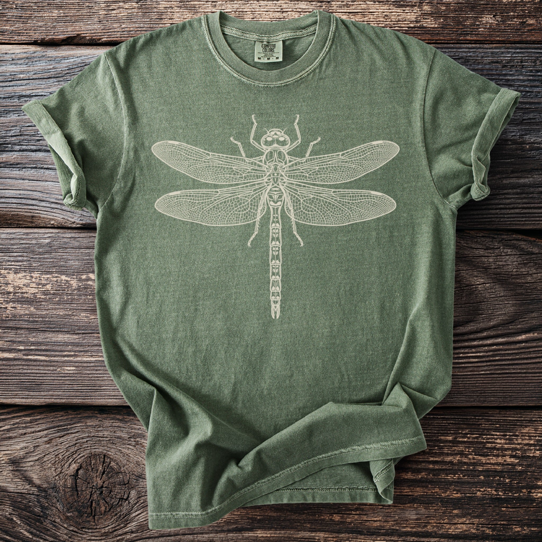 Green t-shirt with a white line drawing of a dragonfly on the front.
