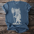 Blue t-shirt with a beige print of a skull-headed figure with antlers holding a staff.