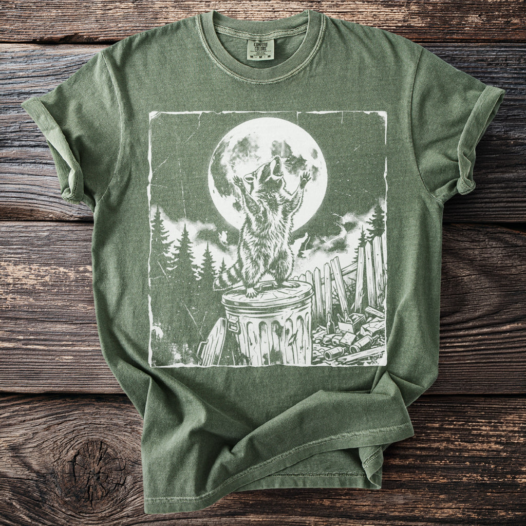 Green t-shirt with a distressed print of a raccoon howling at a full moon.