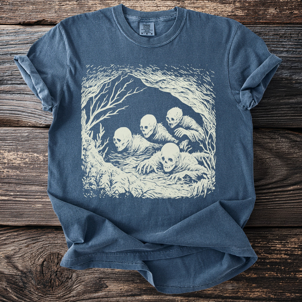 Blue t-shirt with cream-colored skeletal figures emerging from water.