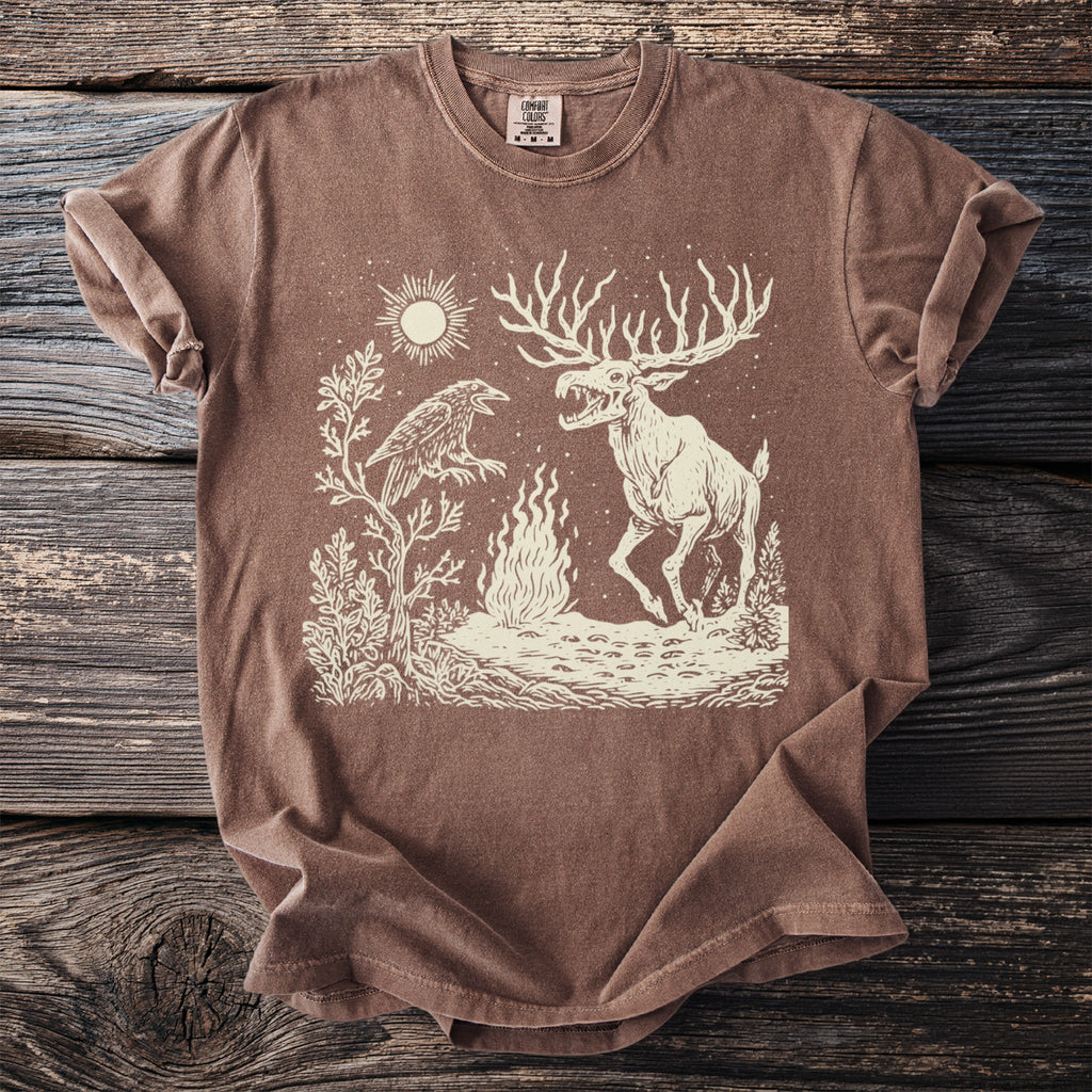 Brown t-shirt with a stylized linocut art of a raven, moose, sun, and fire.