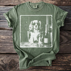 Green t-shirt with a graphic of a dog wearing sunglasses next to champagne.