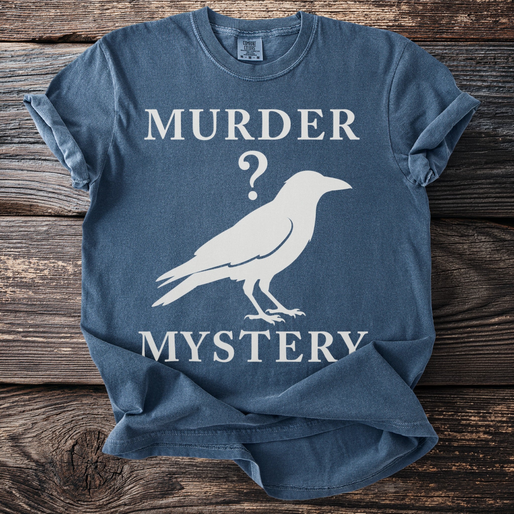 Blue t-shirt with white text "MURDER ?" and a silhouette of a crow, then "MYSTERY".