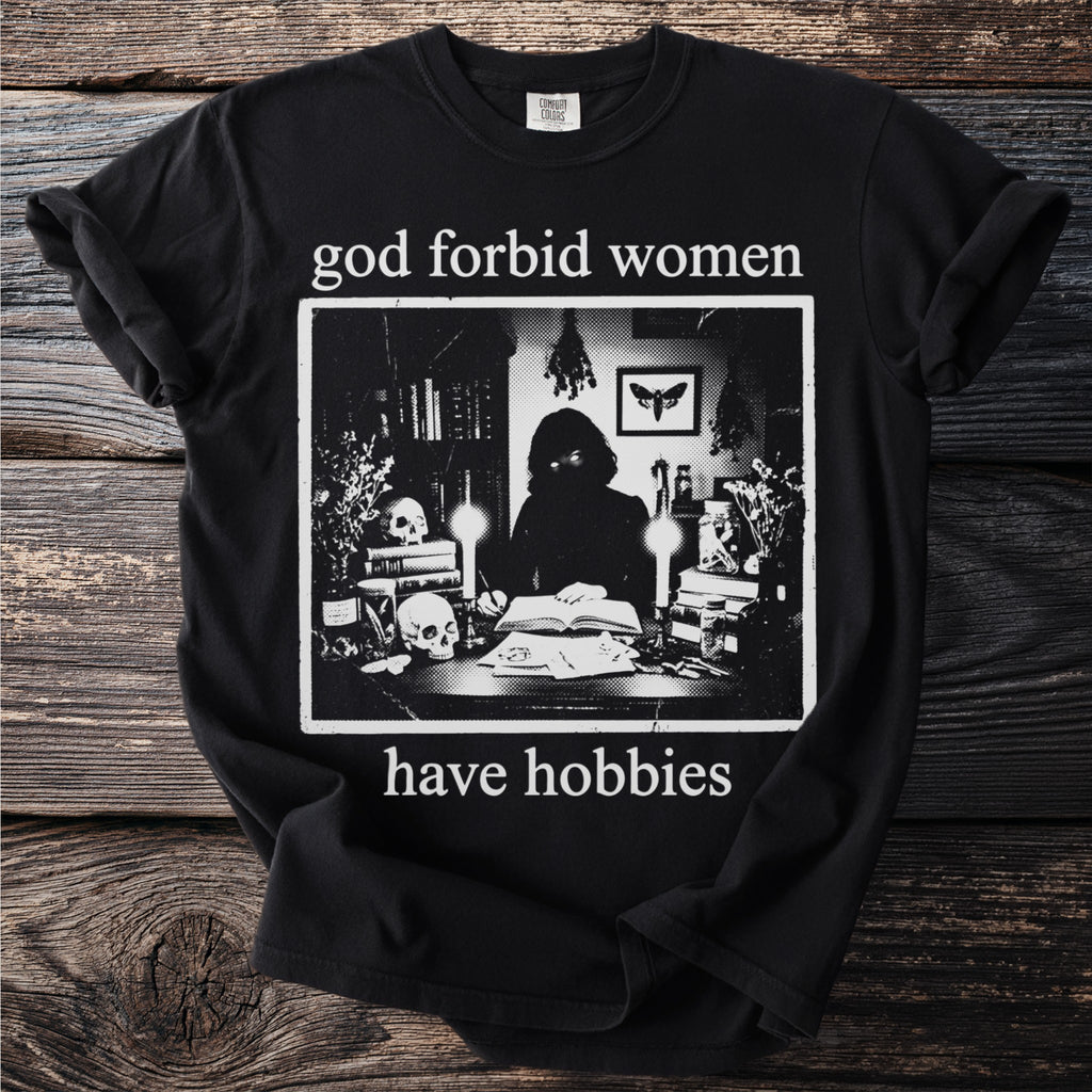 Black t-shirt with "god forbid women have hobbies" text and occult-themed graphic.