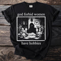 Black t-shirt with "god forbid women have hobbies" text and occult-themed graphic.