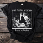 Black t-shirt with "god forbid women have hobbies" text and occult-themed graphic.