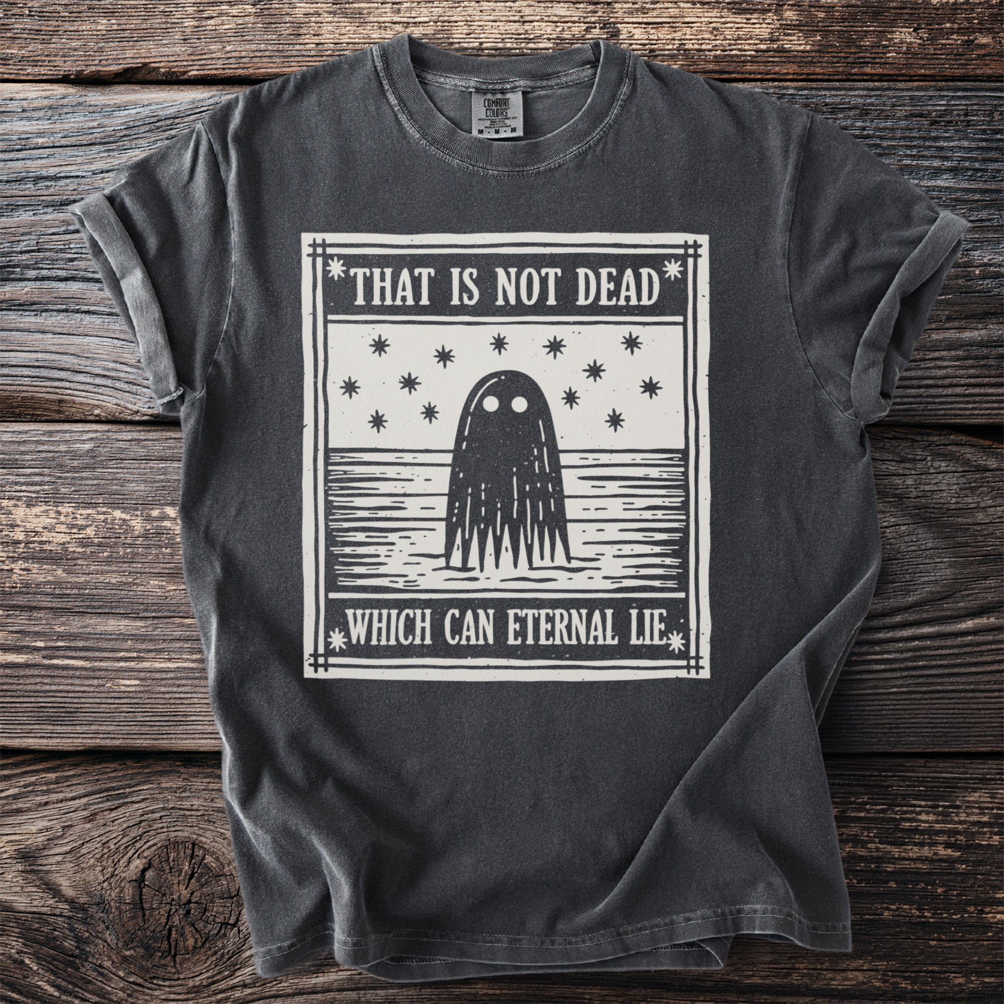 Dark gray t-shirt with ghost graphic and text "That is not dead which can eternal lie".