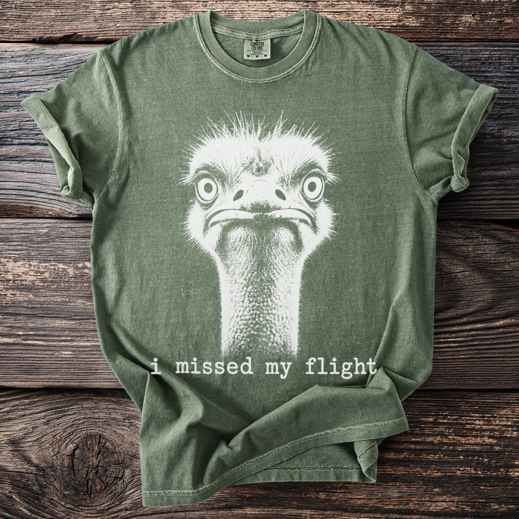 Green t-shirt with white ostrich graphic and text "i missed my flight".