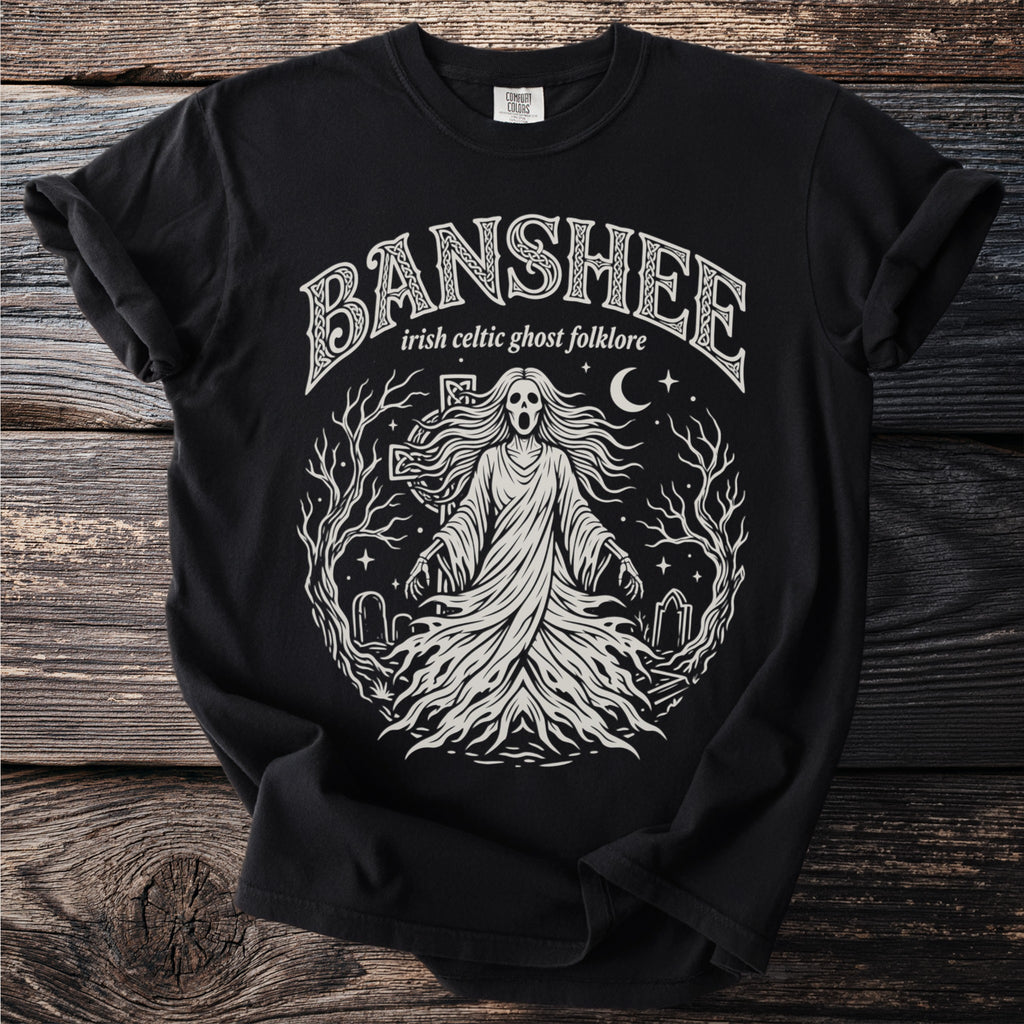 Black t-shirt with a cream graphic of a banshee, tombstones, and trees.