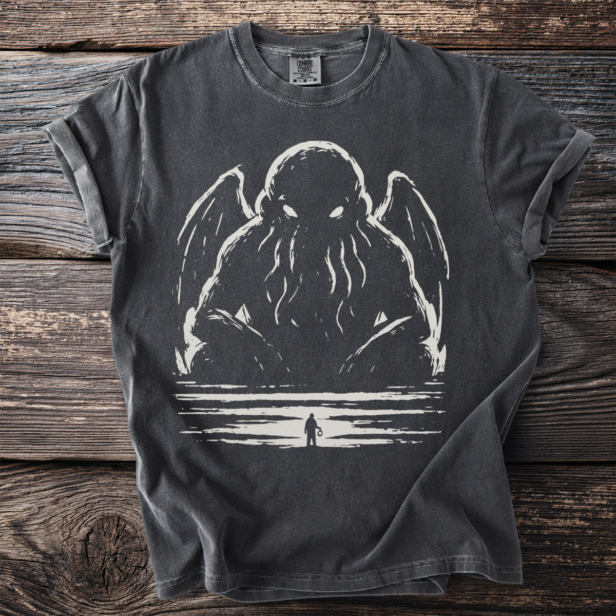 Dark t-shirt with a tentacled creature and silhouetted figure illustration.