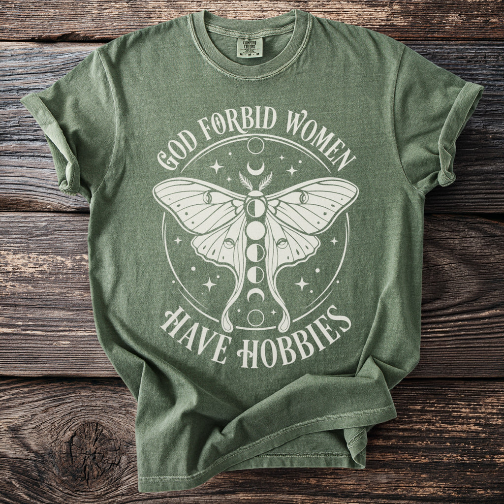 Green t-shirt with moth graphic and text "God Forbid Women Have Hobbies".