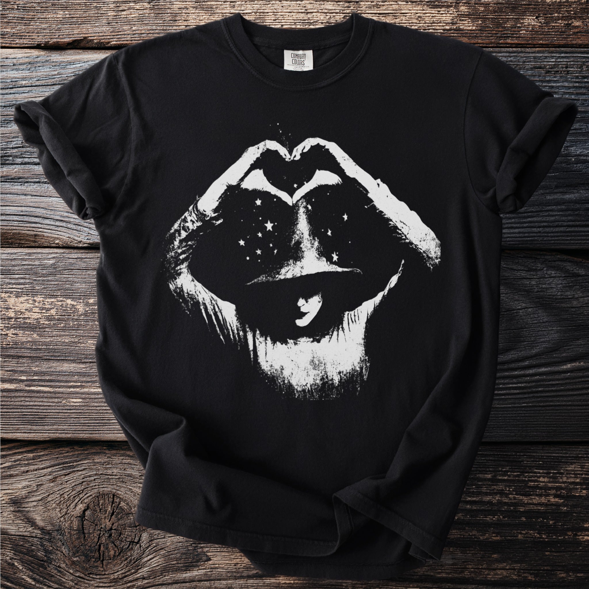 Black t-shirt with white distressed graphic of a person in a hat making a heart symbol with stars.