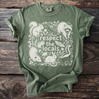Green t-shirt with white illustration of various local animals and the text "respect the locals".