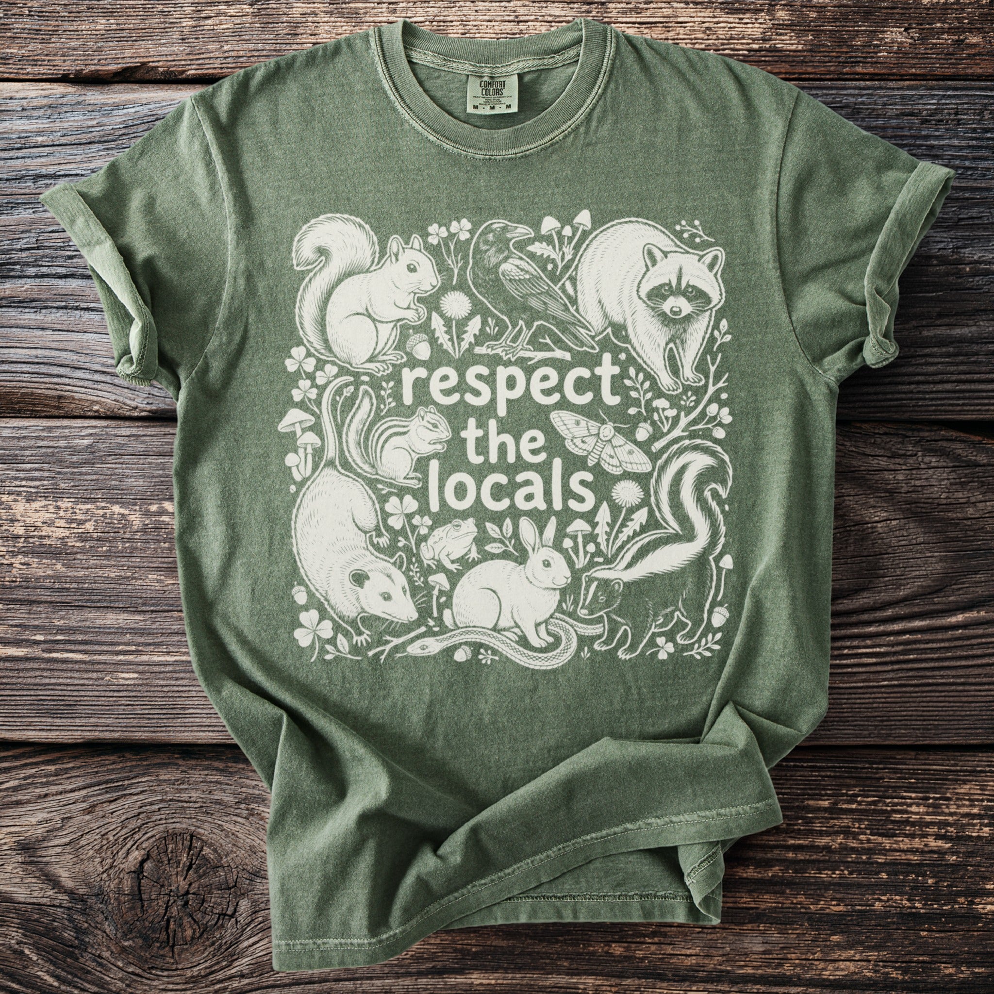 Green t-shirt with white illustration of various local animals and the text "respect the locals".