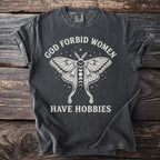Dark gray t-shirt with white graphic and text: "GOD FORBID WOMEN HAVE HOBBIES".