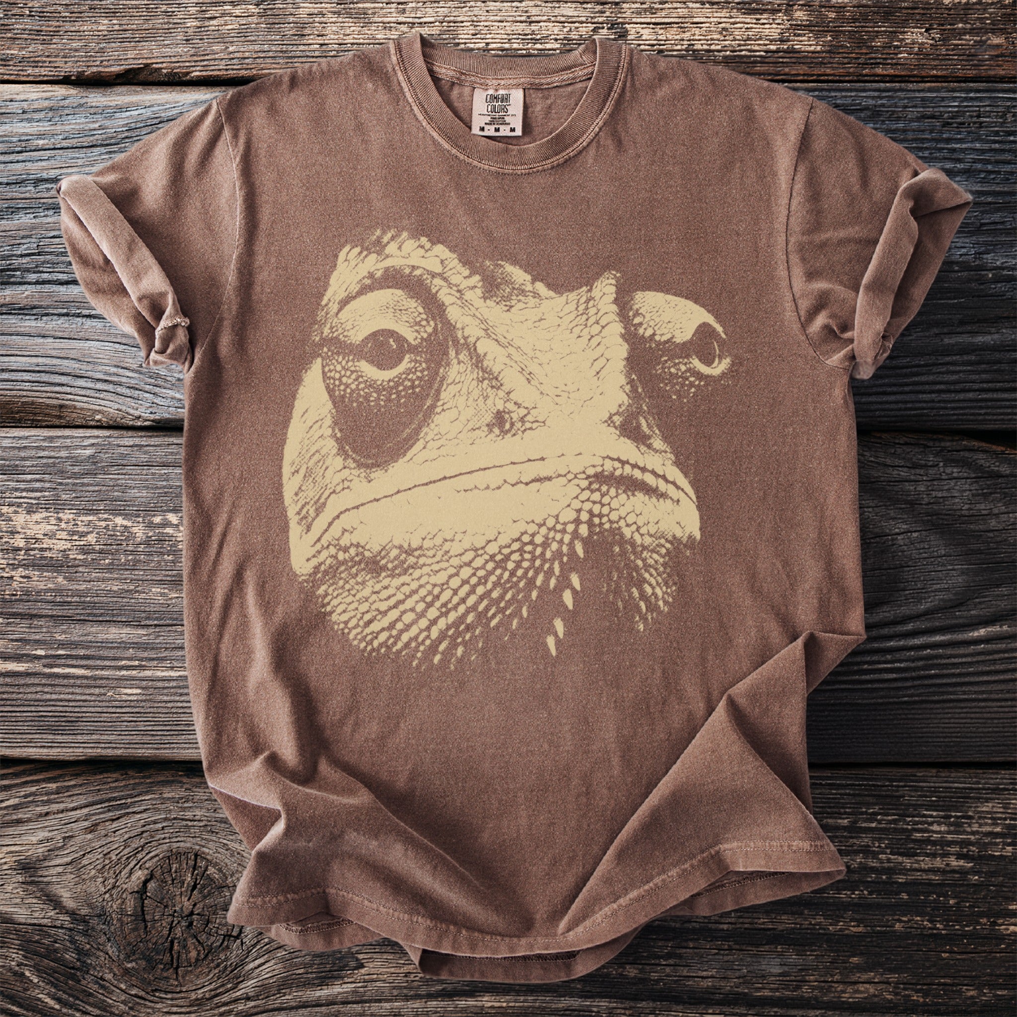 Brown short-sleeve t-shirt with a beige chameleon face graphic and Comfort Colors tag.