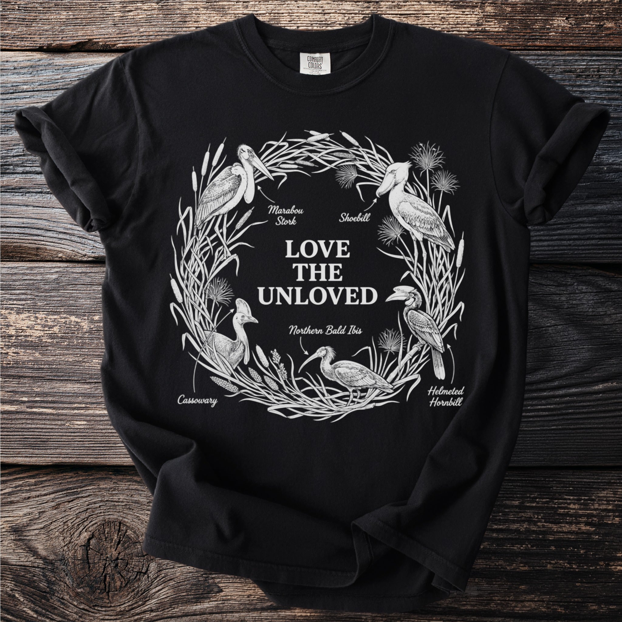 Black t-shirt with white line art of birds and text "LOVE THE UNLOVED"