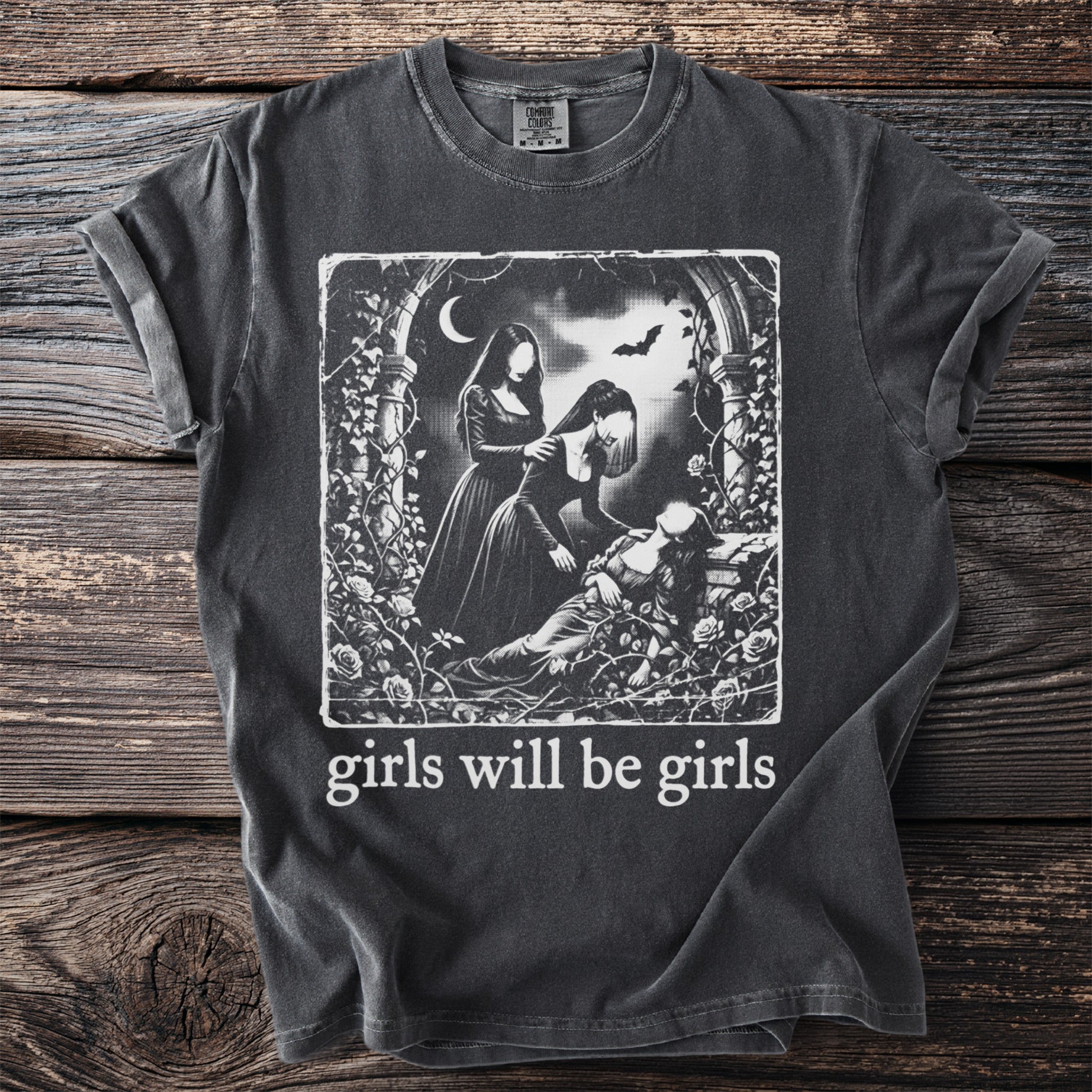 Dark t-shirt with gothic illustration and text "girls will be girls."