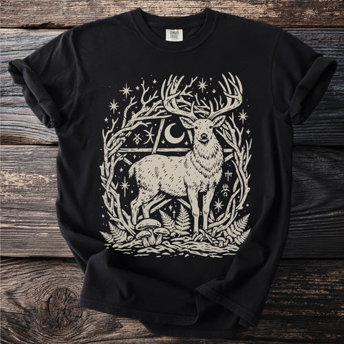 Black t-shirt with a stylized deer graphic among branches, stars, and mushrooms.