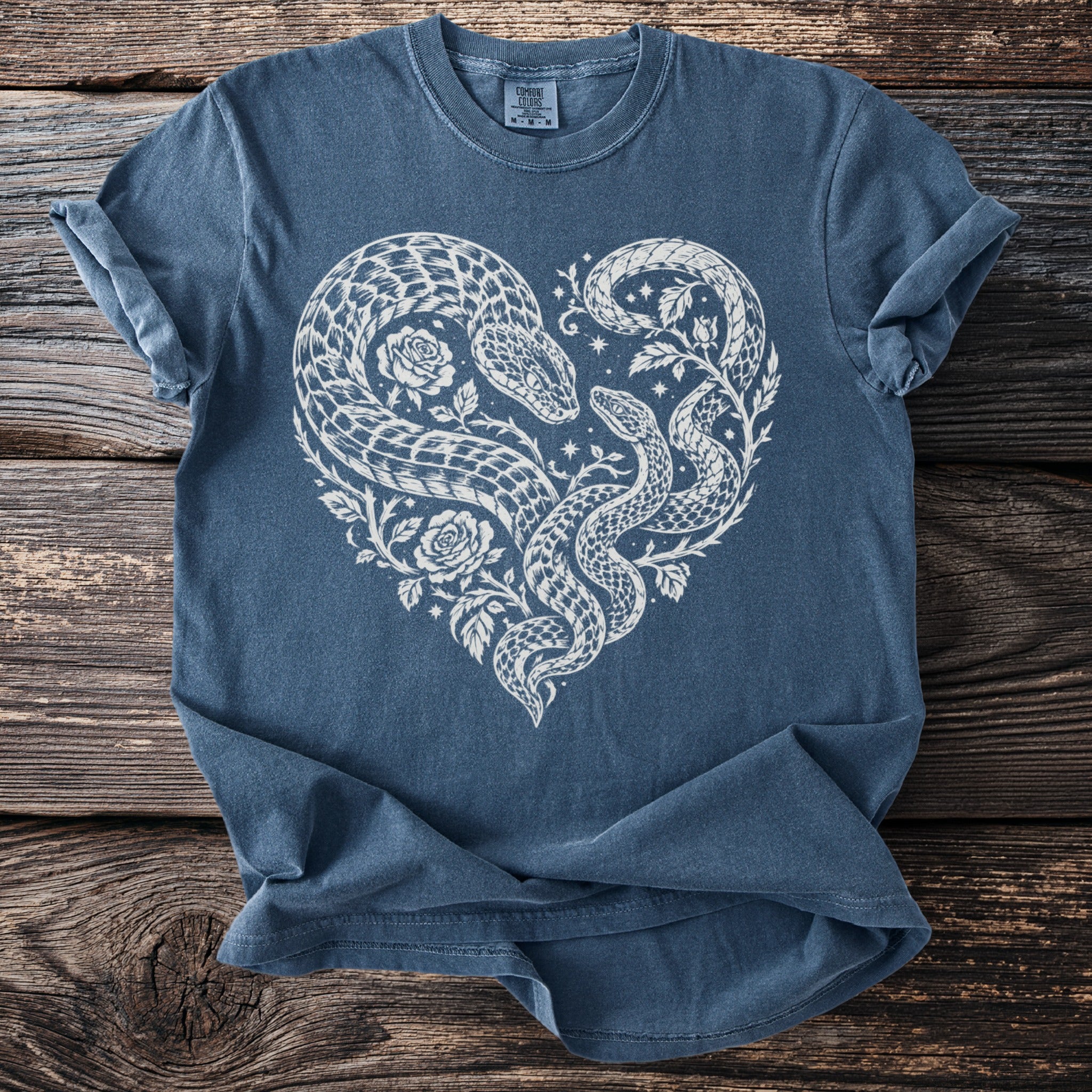 Blue t-shirt with white heart-shaped snake and rose graphic.