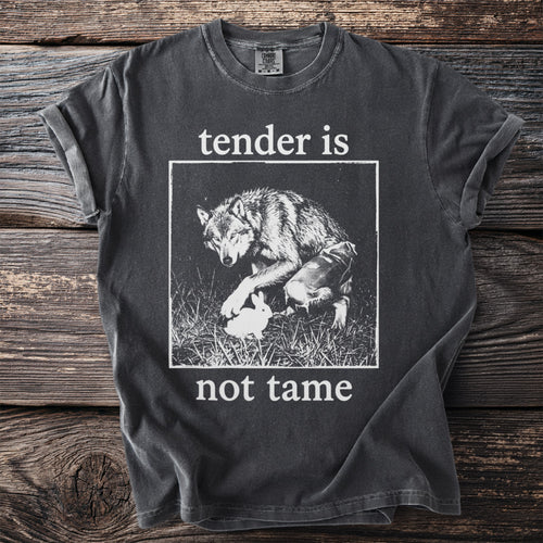 Dark grey t-shirt with a wolf and rabbit graphic and text "tender is not tame".