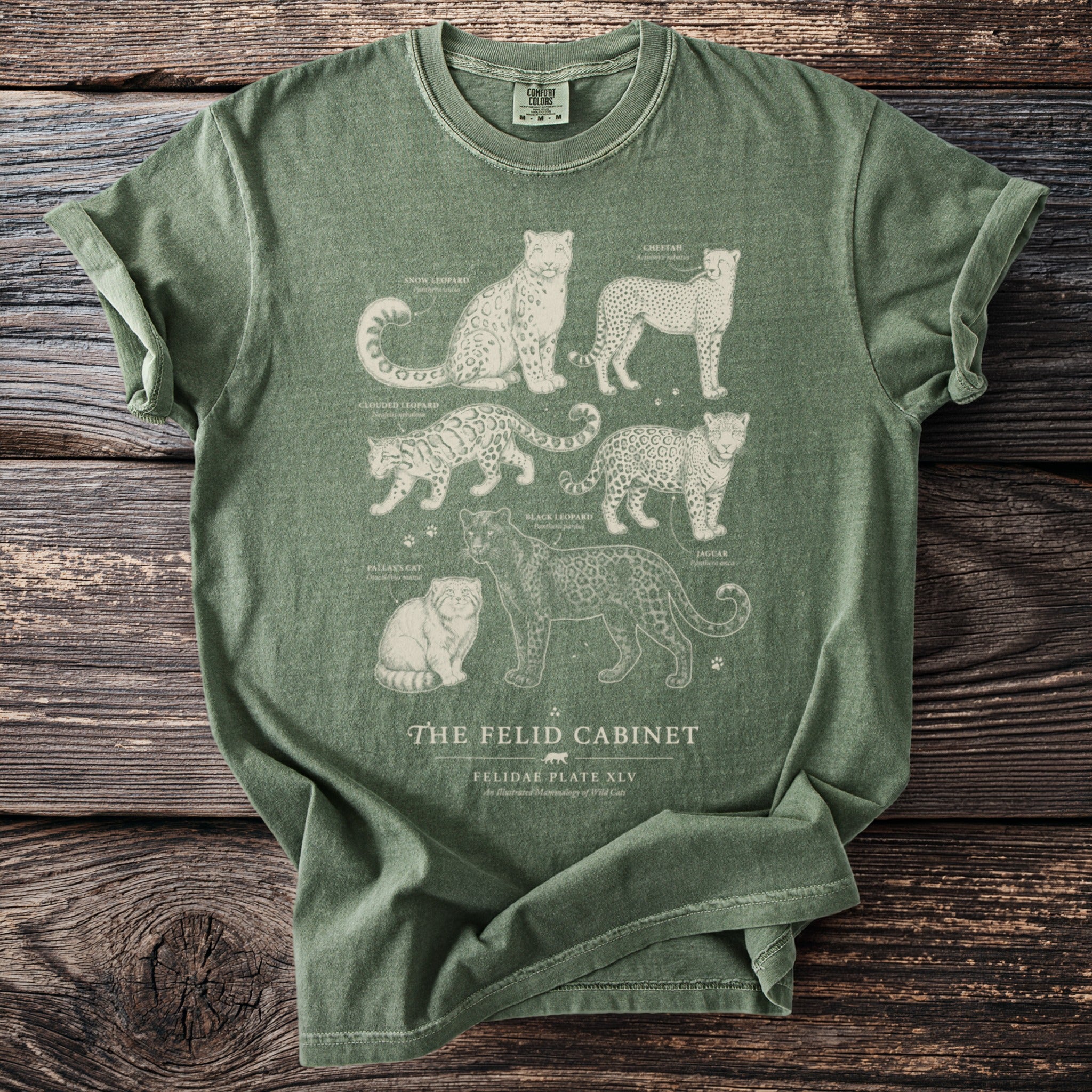 Green t-shirt with illustrations of snow leopard, cheetah, clouded leopard, black leopard, jaguar, and Pallas's cat.