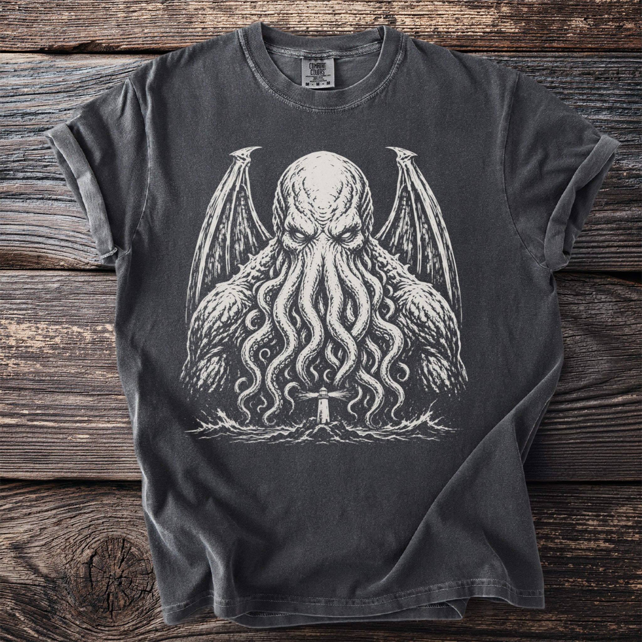 Dark t-shirt with a white graphic of a tentacled creature and a lighthouse.