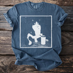 Blue t-shirt with graphic of a black and white cat holding a cigarette and a can.