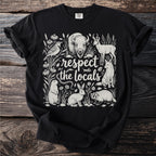 Black t-shirt with line art of diverse wildlife and text "respect the locals".
