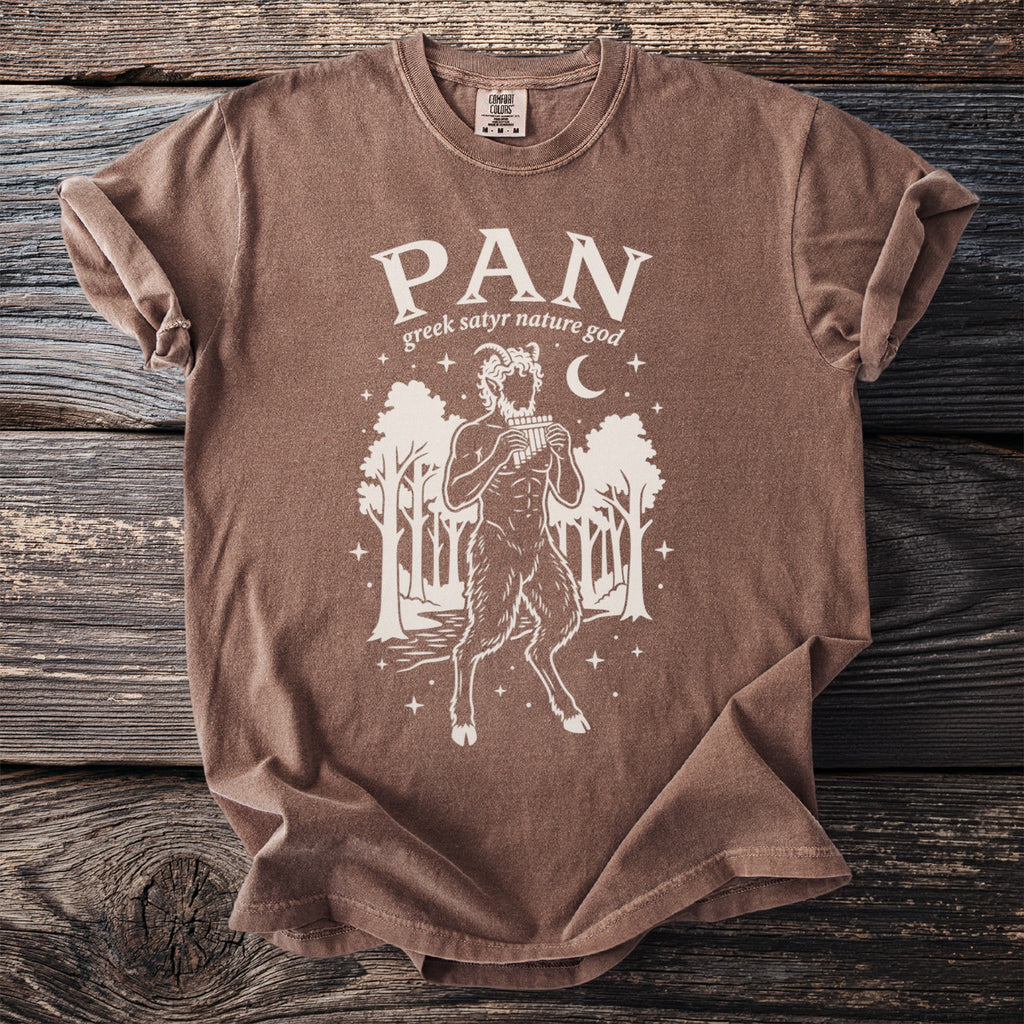Brown t-shirt with print of Pan, god of the wild, playing panpipes.
