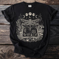 Black t-shirt with a mystical dragonfly, moon phases, potion bottles, and an open book design.