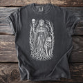 Dark gray t-shirt showing Hel in a thorn grove with a skull staff, wolf, and raven.