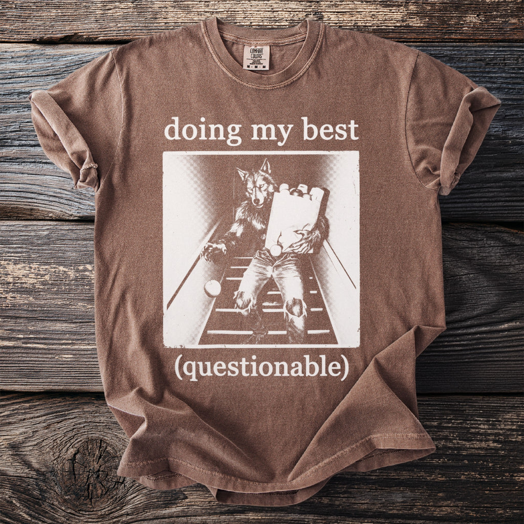 Brown t-shirt with white text "doing my best (questionable)" and werewolf graphic.